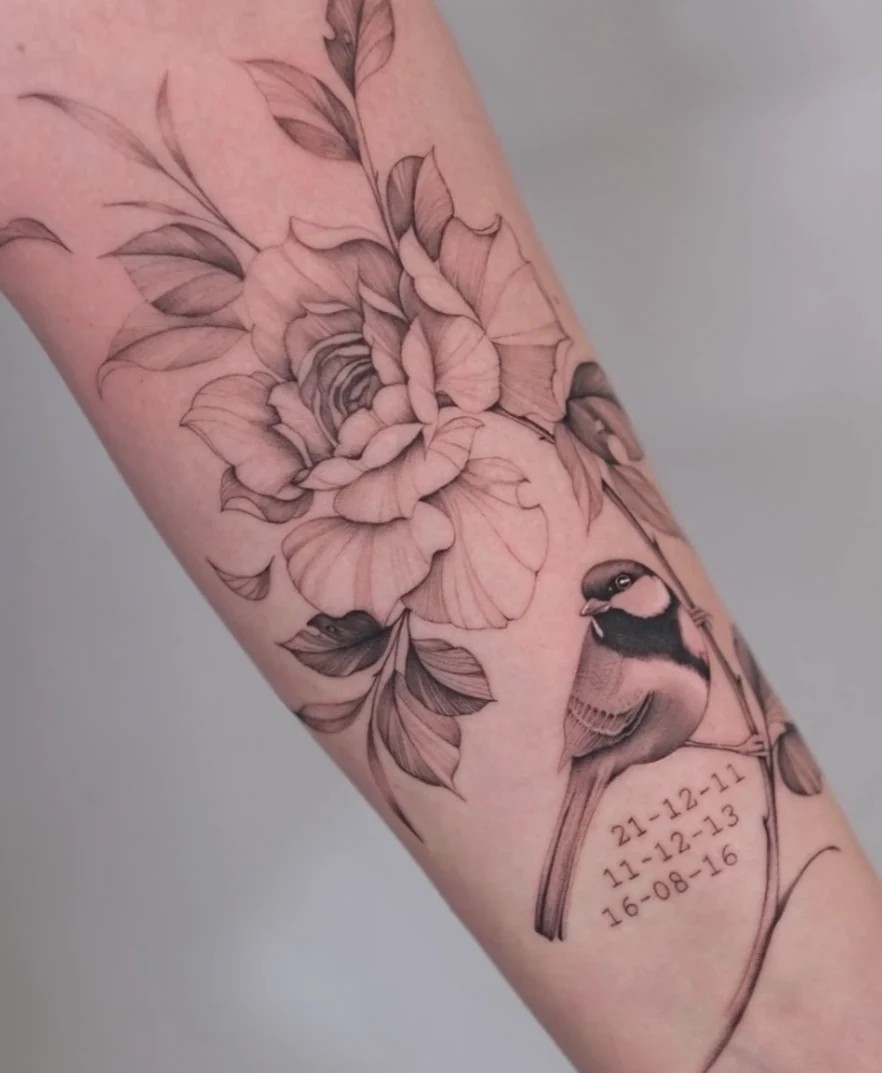 Bloemen en ornamenten tattoo op de onderarm