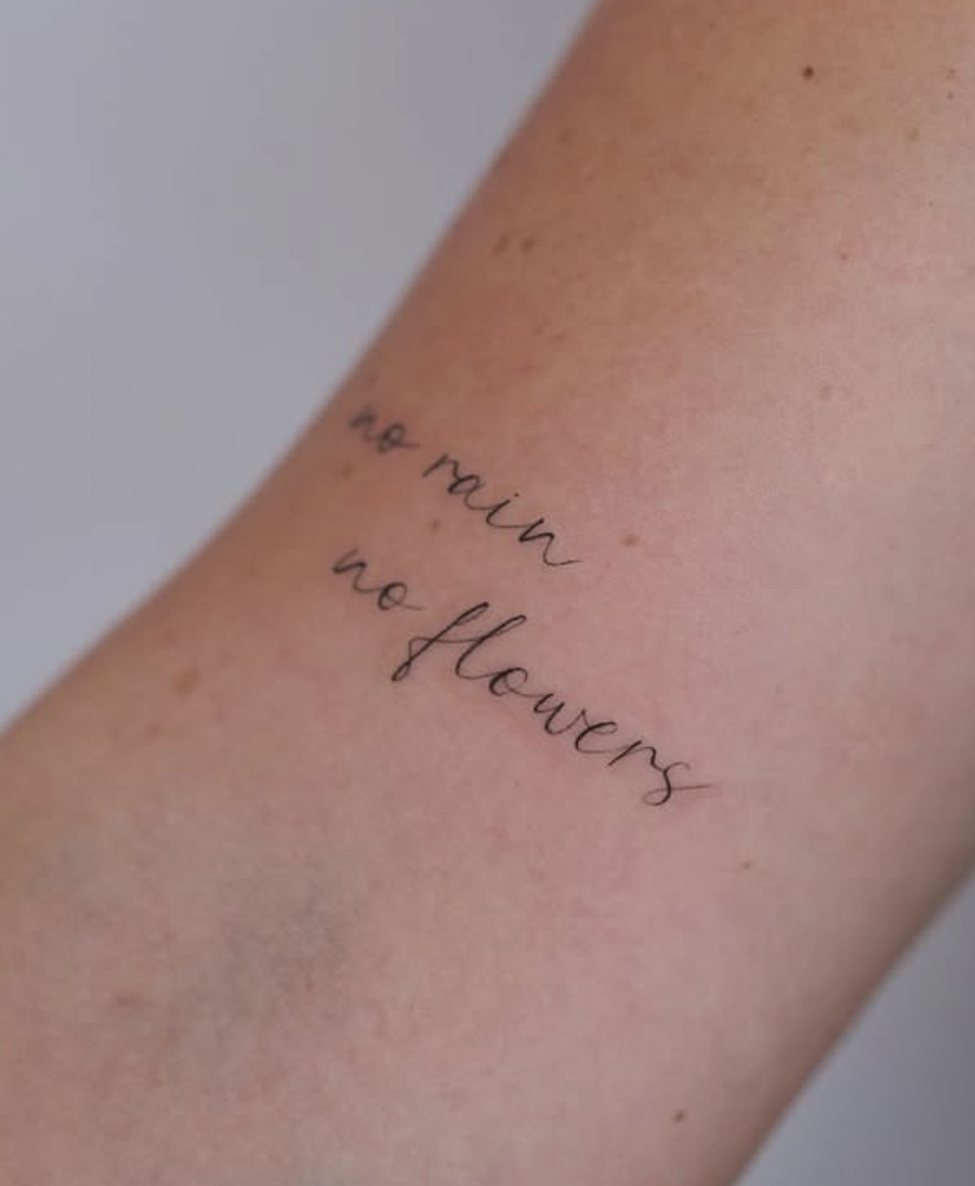 Fineline tattoo met fijn geschreven tekst op de arm