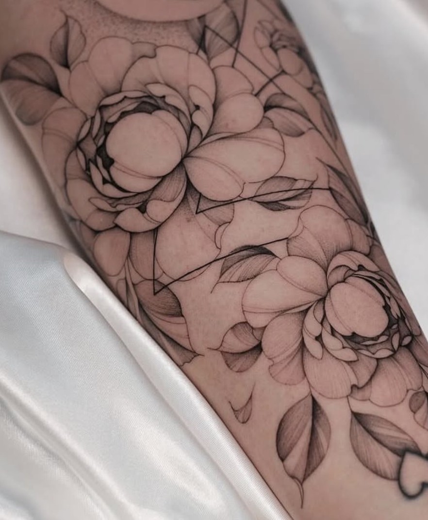 Fineline tattoo met pioenrozen over de onderarm