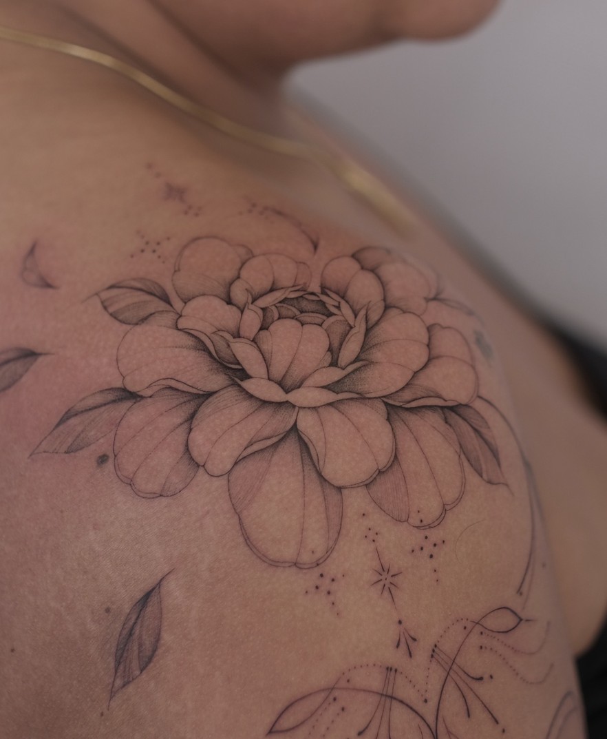 Fineline tattoo van een grote roos op de schouder