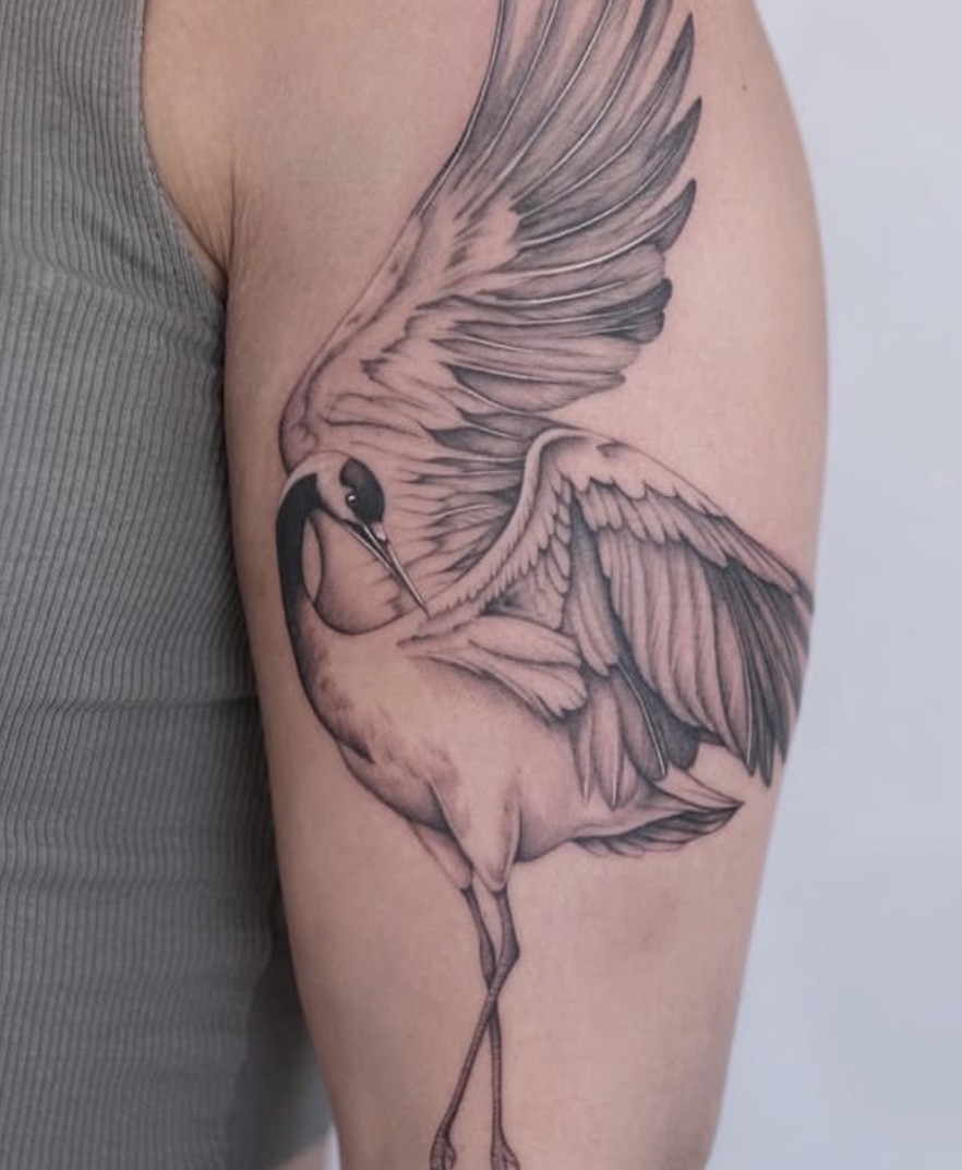 Fineline tattoo van een kraanvogel op de bovenarm