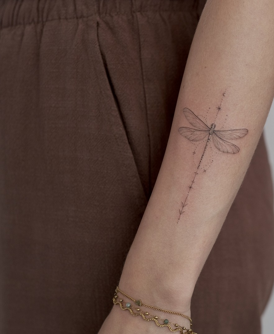Fineline tattoo van een libelle met een fijne lijn op de onderarm