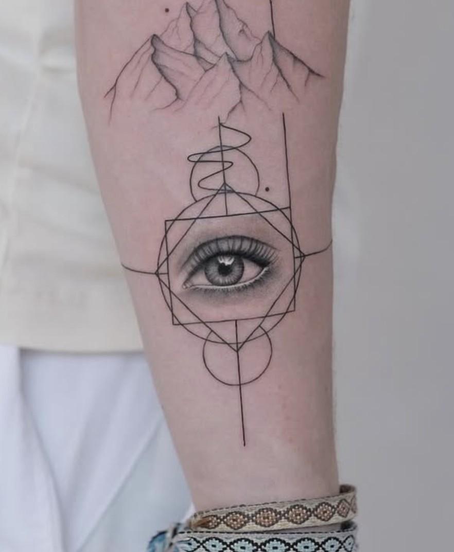 Fineline tattoo van een oog in een geometrische vorm op het scheenbeen