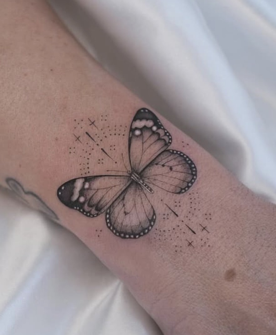 Fineline tattoo van een vlinder met fijne lijnen op de arm