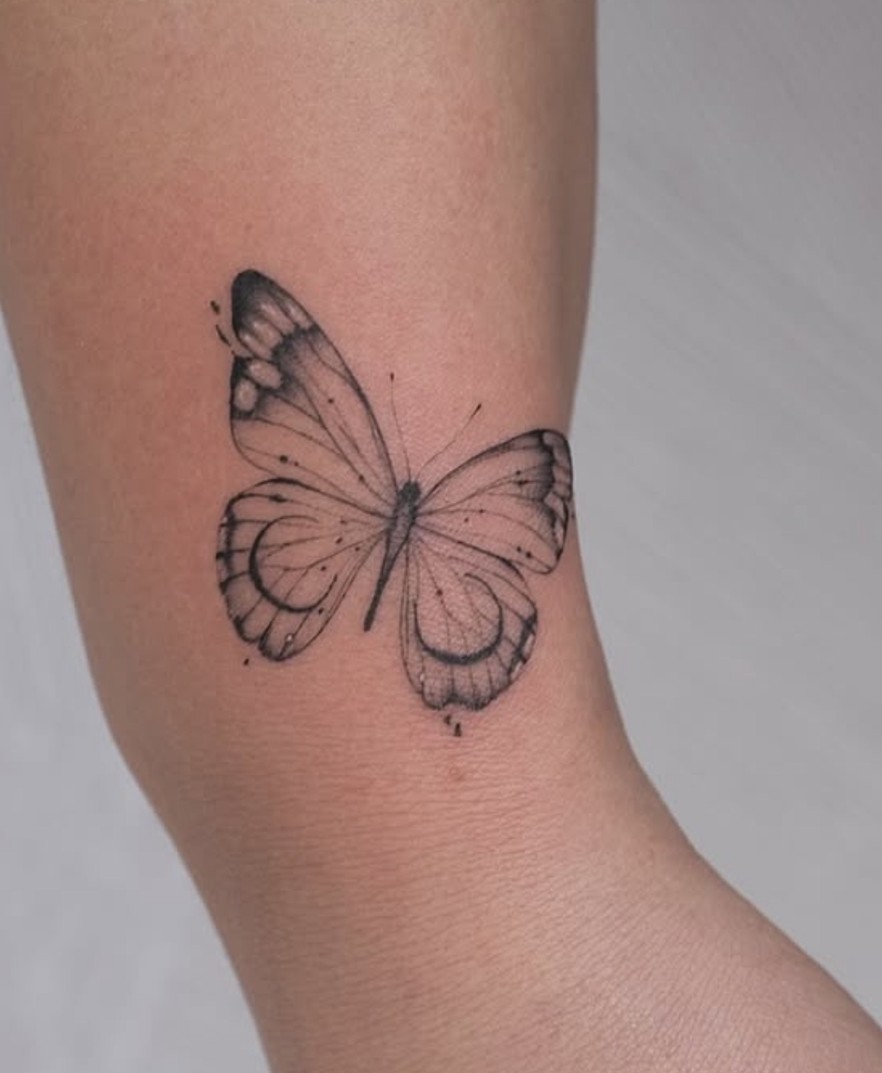 Fineline tattoo van een vlinder op de onderarm