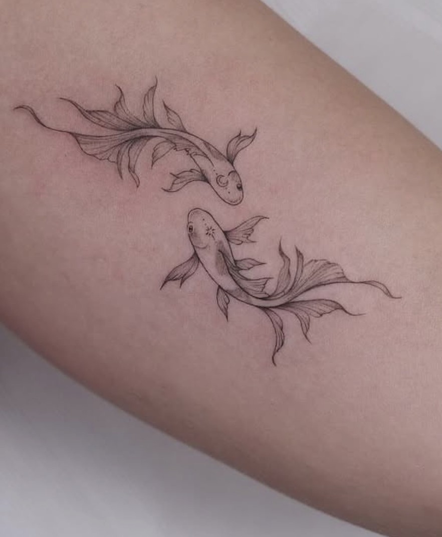 Fineline tattoo van twee koikarpers op de arm