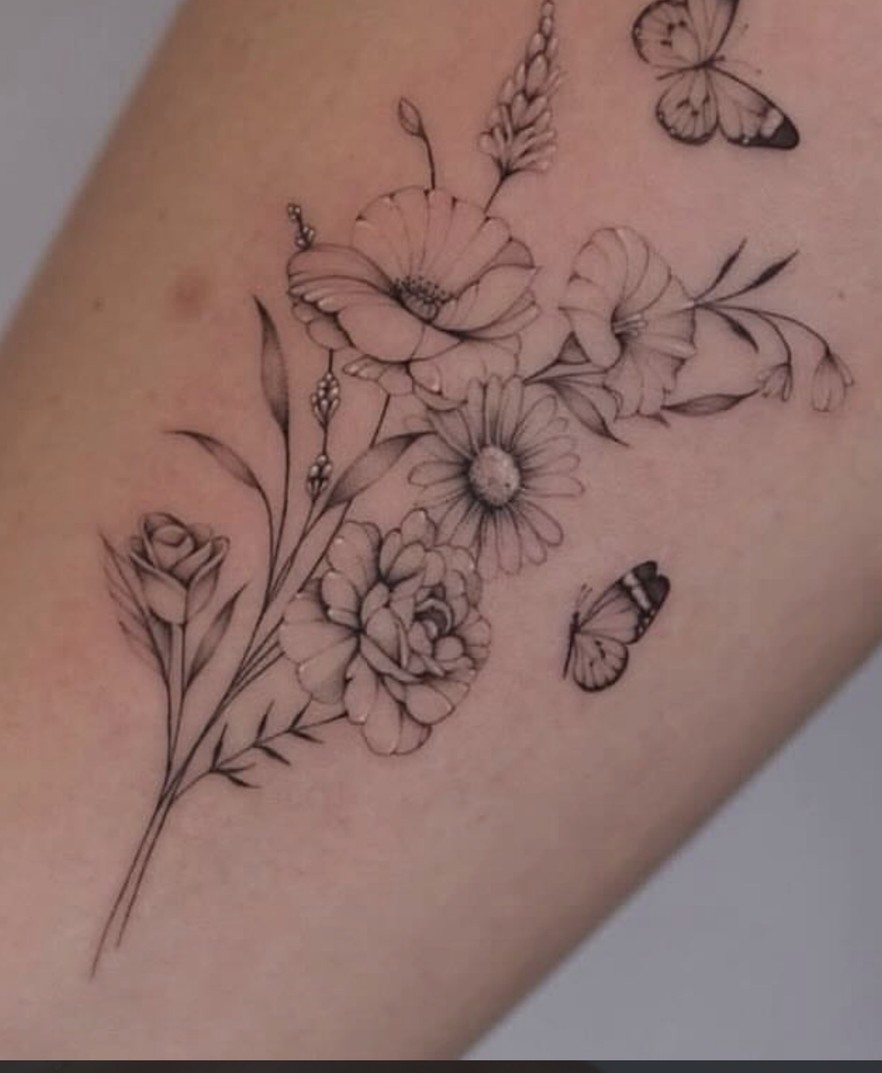 Fineline tattoo van veldbloemen met kleine vlinders