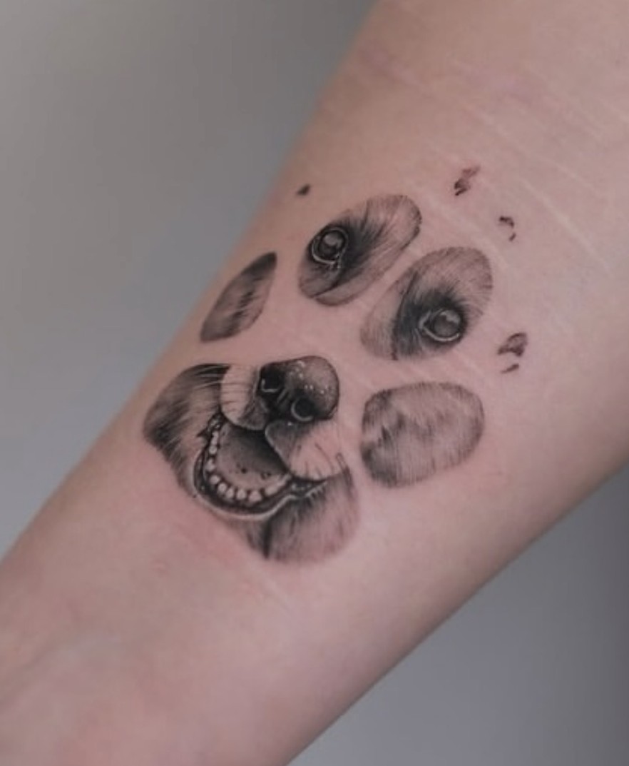 Minirealisme tattoo van een hondenpoot op de onderarm