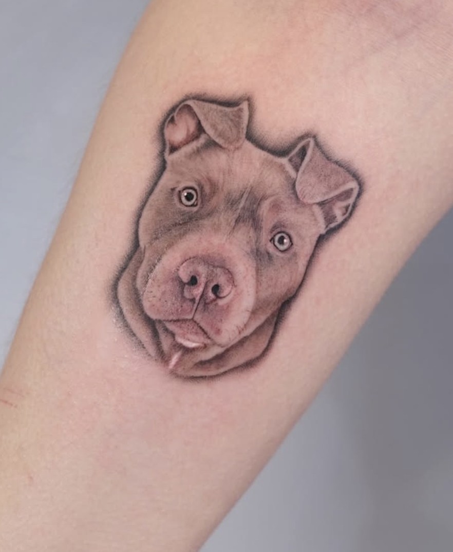 Minirealisme tattoo van een hondenportret op de onderarm