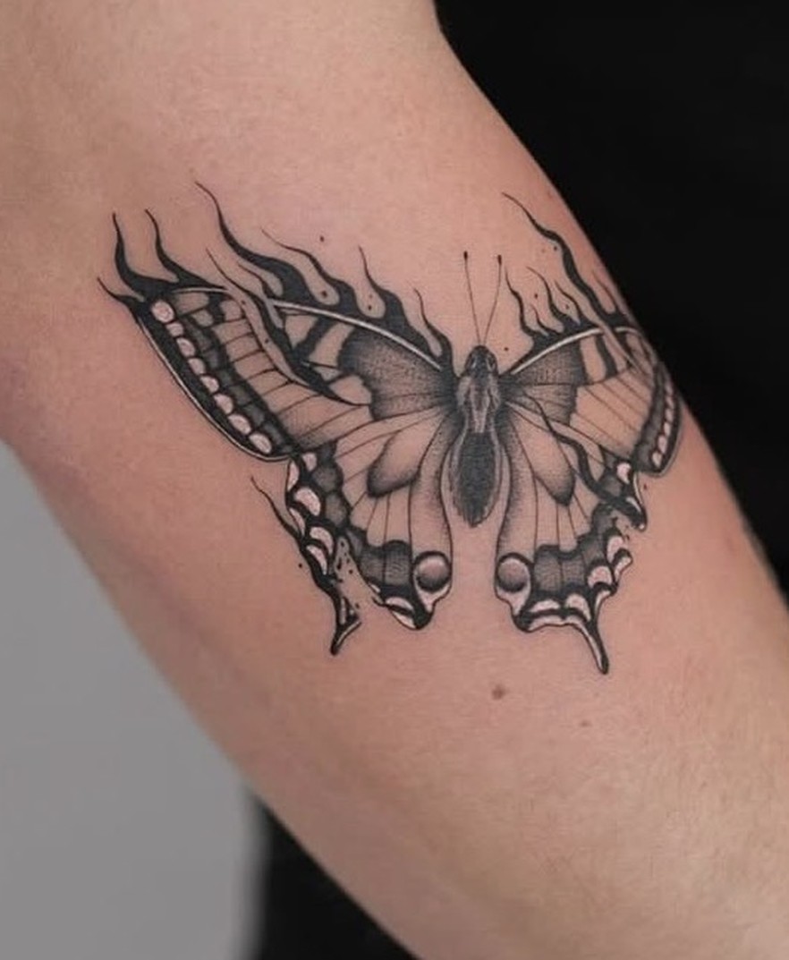 Minirealisme tattoo van een koningspage-vlinder op de bovenarm