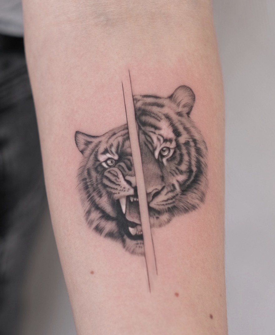 Minirealisme tattoo van een tijgerkop op de onderarm